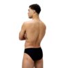גבר בגד ים שחור של Speedo, עומד בצד, רקע לבן.