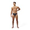 גבר לובש בגד ים שחייה של Speedo, מוכן לשחייה במים.