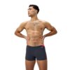 גבר לובש בגד ים שחייה של Speedo, מוכן לשחות, על רקע לבן, דגם.