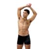 גבר לובש בגד ים שחור של Speedo, מוכן לשחייה במים.