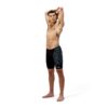 גבר לובש בגד ים קצר של Speedo, עיצוב מודרני וצבעים כהים.