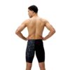 גבר לובש בגד ים שחייה של Speedo, עומד עם גב מופנה, רקע לבן.