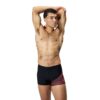 גבר לובש בגד ים ספורטיבי של Speedo, עומד עם ידיים מאחורי הר.